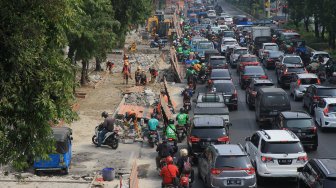 Pekerja menyelesaikan proyek revitalisasi trotoar di Jalan Salemba, Jakarta Pusat, Selasa (3/9). (Suara.com/Angga Budhiyanto)