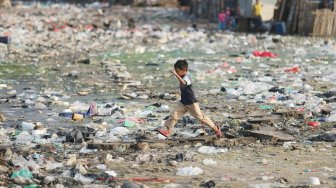 Anak-anak bermain di atas tumpukan sampah di kawasan Kampung Bengek, Penjaringan, Jakarta Utara, Selasa (3/9). [Suara.com/Arya Manggala] 