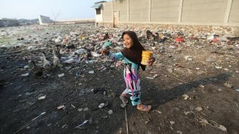 Anak-anak bermain di atas tumpukan sampah di kawasan Kampung Bengek, Penjaringan, Jakarta Utara, Selasa (3/9). [Suara.com/Arya Manggala] 