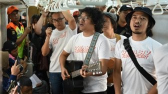 Grup band D'Masiv menghibur pengguna jasa KRL dari stasiun Manggarai menuju Stasiun Jakarta Kota, Senin (2/9). [Suara com/Arya Manggala]