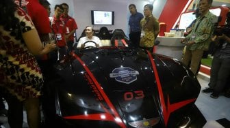 Menteri Koordinator Bidang Kemaritiman Luhut Binsar Panjaitan menaiki mobil listrik Lowo Ireng dalam acara Indonesia Electric Motor Show (IEMS) 2019 di Balai Kartini, Jakarta, Rabu (4/9). [Suara.com/Arya Manggala]