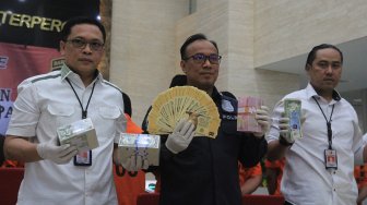 Karopenmas Divhumas Polri Brigjen Pol Dedi Prasetyo (tengah) didampingi petugas Bareskrim memberikan keterangan pers dan menunjukkan bukti berupa uang palsu mata uang asing dollar Singapura dan Brunei Darussalam di Bareskrim Polri, Jakarta, Rabu (4/9). (Suara.com/Angga Budhiyanto)