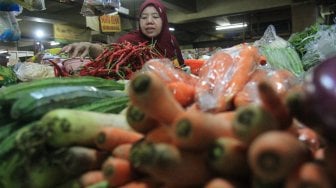 Pedagang sayuran menata dagangannya di Pasar Minggu, Jakarta, Kamis (5/9). [Suara.com/Angga Budhiyanto]