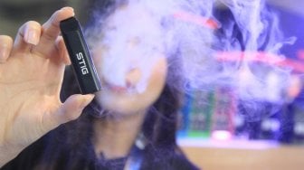 Sales Promotion Girl dari Stig menunjukkan salah satu produk pada acara "Vape Fair" di JCC, Jakarta, Sabtu (7/9). (Suara.com/Angga Budhiyanto)