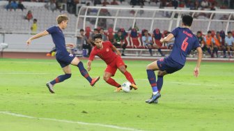 Winger Timnas Indonesia, Andik Vermansah (tengah) berebut bola dengan pemain Timnas Thailand dalam laga kualifikasi Piala Dunia 2022 Zona Asia Grup G di Stadion Utama Gelora Bung Karno, Selasa (10/9/2019). [Suara.com/Arya Manggala]