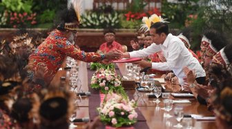 Presiden Joko Widodo (kanan) menerima map berisi saran dari perwakilan tokoh Papua Abisai Rollo (kiri) dalam pertemuan di Istana Negara, Jakarta, Selasa (10/9). [ANTARA FOTO/Akbar Nugroho Gumay]