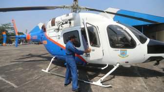 Petugas memeriksa Helikopter jenis Bell 429/P-3203 di Hanggar 3 Ditpoludara Korpolairud Polri, Jakarta, Rabu (11/9). [Suara.com/Arya Manggala]