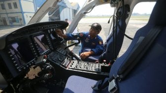 Petugas memeriksa Helikopter jenis Bell 429/P-3203 di Hanggar 3 Ditpoludara Korpolairud Polri, Jakarta, Rabu (11/9). [Suara.com/Arya Manggala]