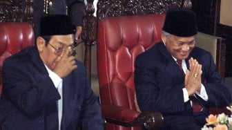 Presiden Indonesia yang baru terpilih, Abdurrahman Wahid (kiri) dan mantan Presiden Indonesia B.J. Habibie memberi isyarat di Parlemen di Jakarta pada tanggal 20 Oktober 1999.[Foto/AFP]