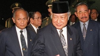 Presiden Indonesia Suharto bersama Wakil Presiden B J Habibie (kiri) dan Menteri Koordinator Politik dan Keamanan Faisal Tanjung (kanan) pada saat kedatangan dari KTT G-15 Kairo di bandara,Jakarta (14 Mei 1998). [Foto/AFP]