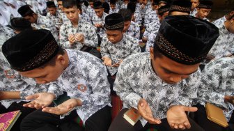 Sejumlah pelajar membaca Surat Yasin di SMAN-1 Lhokseumawe, Aceh, Jumat (13/9).  [ANTARA FOTO/Rahmad]