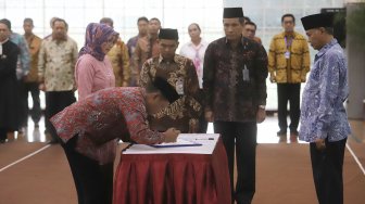 Fitroh Roncohyanto (kiri) melakukan penandatanganan saat pelantikan Sekjen dan Direktur Penuntut KPK yang baru di Gedung Merah Putih KPK, Jakarta, Senin (16/9). (Suara.com/Angga Budhiyanto)

