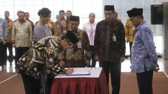 Cahya Harefa (kiri) melakukan penandatanganan saat pelantikan Sekjen dan Direktur Penuntut KPK yang baru di Gedung Merah Putih KPK, Jakarta, Senin (16/9). (Suara.com/Angga Budhiyanto)
