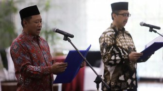 Fitroh Roncohyanto (kiri) bersama dengan Cahya Harefa (kanan) melakukan sumpah saat pelantikan Sekjen dan Direktur Penuntut KPK yang baru di Gedung Merah Putih KPK, Jakarta, Senin (16/9). (Suara.com/Angga Budhiyanto)

