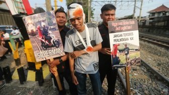 Petugas KAI Daop 1 Jakarta melakukan sosialisasi keselamatan di perlintasan sebidang Bukit Duri Manggarai, Jakarta, Selasa (17/9). [Suara.com/Arya Manggala]