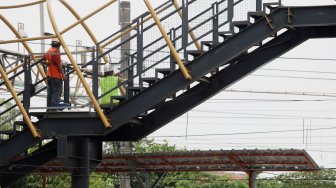 Pekerja menyelesaikan proyek jembatan penyeberangan orang (JPO) di kawasan Pasar Minggu, Jakarta Selatan, Selasa (17/9). [Suara.com/Angga Budhiyanto]
