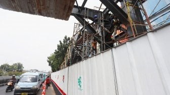 Pekerja menyelesaikan proyek jembatan penyeberangan orang (JPO) di kawasan Pasar Minggu, Jakarta Selatan, Selasa (17/9). [Suara.com/Angga Budhiyanto]
