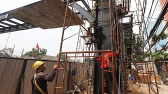 Pekerja menyelesaikan proyek jembatan penyeberangan orang (JPO) di kawasan Pasar Minggu, Jakarta Selatan, Selasa (17/9). [Suara.com/Angga Budhiyanto]
