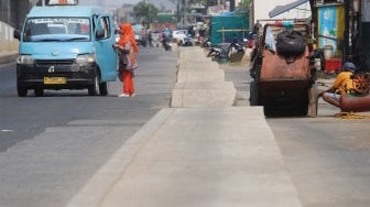 Sejumlah kendaraan melintas di samping trotoar yang berada di tengah jalan di Jalan Inspeksi Saluran Kalimalang, Jakarta, Rabu (18/9). [Suara.com/Angga Budhiyanto]