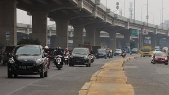 Sejumlah kendaraan melintas di samping trotoar yang berada di tengah jalan di Jalan Inspeksi Saluran Kalimalang, Jakarta, Rabu (18/9). [Suara.com/Angga Budhiyanto]