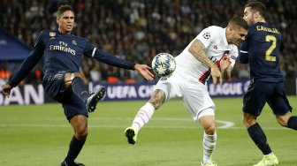 Bek Real Madrid asal Raphael Varane menjaga pemain depan Paris Saint-Germain Mauro Icardi selama pertandingan Liga Champions Grup A antara Paris Saint-Germain melawan Real Madrid, di Stadion Parc des Princes, Paris, Perancis, Kamis (19/9) dini hari WIB. [Thomas SAMSON / AFP]