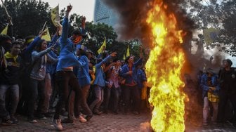 Mahasiswa yang tergabung dalam Pergerakan Mahasiswa Islam Indonesia (PMII) menyerang petugas kepolisian yang berusaha memadamkan api saat melakukan aksi unjuk rasa di depan gedung KPK, Jakarta, Jumat (20/9). [ANTARA FOTO/Muhammad Adimaja]