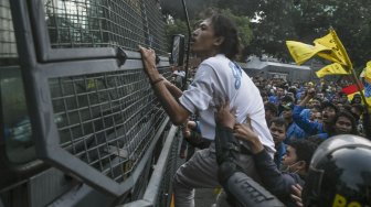 Mahasiswa yang tergabung dalam Pergerakan Mahasiswa Islam Indonesia (PMII) menyerang petugas kepolisian yang berusaha memadamkan api saat melakukan aksi unjuk rasa di depan gedung KPK, Jakarta, Jumat (20/9). [ANTARA FOTO/Muhammad Adimaja]