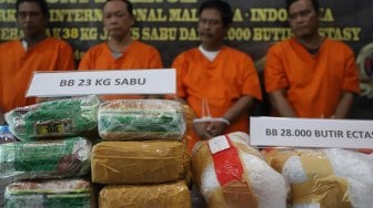 Petugas menunjukkan tersangka dan barang bukti berupa narkoba jenis sabu dan ekstasi saat rilis kasus penggagalan penyelundupan narkoba dari Malaysia di Bareskrim Polri, Jakarta, Jumat (20/9). [Suara.com/Angga Budhiyanto]