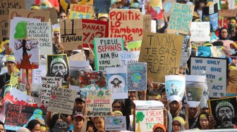 Aktivis dari berbagai organisasi lingkungan berjalan menuju Taman Aspirasi Monas saat aksi terkait krisis iklim di Jalan Medan Merdeka Barat, Jakarta Pusat, Jumat (20/9). [Suara.com/Arya Manggala]