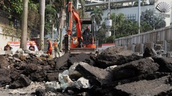 Pekerja menyelesaikan proyek revitalisasi trotoar di sekitaran Bundaran Hotel Indonesia, Jakarta, Minggu (22/9). [Suara.com/Angga Budhiyanto]