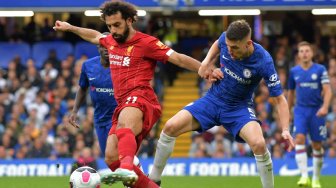 Pemain depan Liverpool Mohamed Salah (kiri) bersaing dengan pemain tengah Chelsea Jorginho (kanan) selama pertandingan sepak bola Liga Inggris antara Chelsea melawan Liverpool di Stamford Bridge, London, Inggris, Minggu (22/9). [OLLY GREENWOOD / AFP]