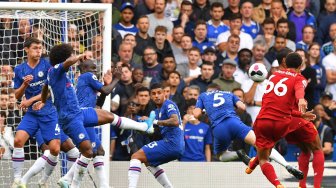 Bek Liverpool Trent Alexander-Arnold menembak untuk mencetak gol pembuka selama pertandingan sepak bola Liga Inggris antara Chelsea melawan Liverpool di Stamford Bridge, London, Inggris, Minggu (22/9). [OLLY GREENWOOD]