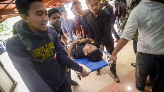 Seorang mahasiswa korban bentrokan saat aksi unjuk rasa ditandu untuk menjalani perawatan di aula kampus Universitas Islam Bandung (Unisba), Jawa Barat, Selasa (24/9).  [ANTARA FOTO/Raisan Al Farisi]