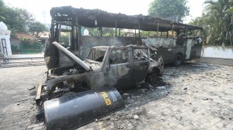 Bus TNI yang hangus terbakar pasca unjukrasa mahasiswa di Jalan Gelora, Senayan, Jakarta, Rabu (25/9). [Suara.com/Arya Manggala]
