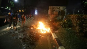 Pos Polisi dibakar saat aksi menolak UU KPK yang berakhir ricuh di Jalan Gerbang Pemuda, Senayan, Jakarta, Selasa (24/9). [Suara.com/Arya Manggala]