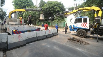 Petugas menutup Jalan Gelora di belakang Gedung DPR, Jalan Gelora, Senayan, Jakarta, Rabu (25/9). [Suara.com/Arya Manggala]
