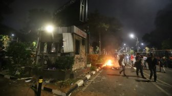 Pos Polisi dibakar saat aksi menolak UU KPK yang berakhir ricuh di Jalan Gerbang Pemuda, Senayan, Jakarta, Selasa (24/9). [Suara.com/Arya Manggala]