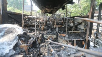 Bus TNI yang hangus terbakar pasca unjukrasa mahasiswa di Jalan Gelora, Senayan, Jakarta, Rabu (25/9). [Suara.com/Arya Manggala]
