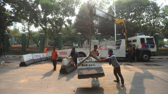 Petugas menutup Jalan Gelora di belakang Gedung DPR, Jalan Gelora, Senayan, Jakarta, Rabu (25/9). [Suara.com/Arya Manggala]
