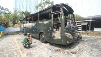 Bus TNI yang hangus terbakar pasca unjukrasa mahasiswa di Jalan Gelora, Senayan, Jakarta, Rabu (25/9). [Suara.com/Arya Manggala]
