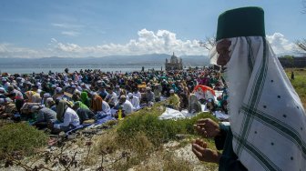 Umat muslim melaksanakan zikir bersama mengenang bencana gempa, tsunami, dan likuefaksi di depan Masjid Arqam Baburrahman yang amblas ke laut di Pantai Kampung Lere, Palu, Sulawesi Tengah, Sabtu (28/9). [ANTARA FOTO/Basri Marzuki]