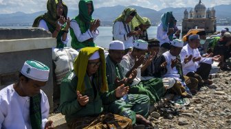 Umat muslim melaksanakan zikir bersama mengenang bencana gempa, tsunami, dan likuefaksi di depan Masjid Arqam Baburrahman yang amblas ke laut di Pantai Kampung Lere, Palu, Sulawesi Tengah, Sabtu (28/9). [ANTARA FOTO/Basri Marzuki]