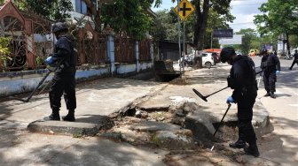 Personel Brimob Polda Sultra melakukan pencarian selongsong peluru saat olah TKP tertembaknya Almarhum Immawan Randi di Jalan Abdulah Silondae, Kendari, Sulawesi Tenggara, Sabtu (28/9). [Antara Foto]