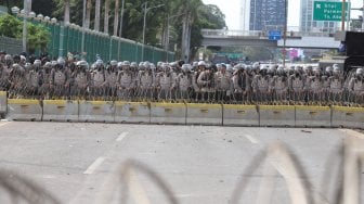 Petugas Kepolisian melakukan pengamanan di sekitar Gedung DPR RI, Jakarta, Senin (30/9). [Suara.com/Angga Budhiyanto]