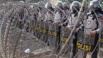 Petugas Kepolisian melakukan pengamanan di sekitar Gedung DPR RI, Jakarta, Senin (30/9). [Suara.com/Angga Budhiyanto]