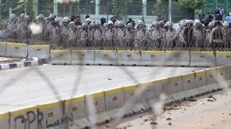 Petugas Kepolisian melakukan pengamanan di sekitar Gedung DPR RI, Jakarta, Senin (30/9). [Suara.com/Angga Budhiyanto]