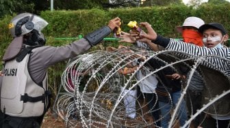 Seorang polisi memberikan minuman dalam kemasan kepada sejumlah pengunjuk rasa di Jalan Gatot Subroto, dekat kompleks Parlemen, Jakarta, Senin (30/9). ANTARA FOTO/Aditya Pradana Putra