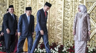 Presiden Joko Widodo (kanan) bersama Wakil Presiden Jusuf Kalla (kiri) memasuki ruang pelantikan anggota DPR RI di Kompleks Parlemen, Senayan, Jakarta Selasa (1/10). [ANTARA FOTO/Galih Pradipta]