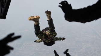 Prajurit TNI melakukan  terjun bebas (free fall) dari pesawat udara CN 295 milik Skadron Udara 2 Lanud Halim Perdanakusuma di ketinggian 7000 kaki di atas Lanud Halim Perdanakusuma, Jakarta Timur, Kamis (3/10). [ANTARA FOTO/M Risyal Hidayat]