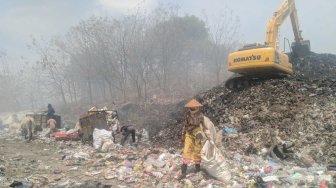 Tak Peduli Pekat Asap Kebakaran TPA Putri Cempo, Sainem Terus Kais Sampah